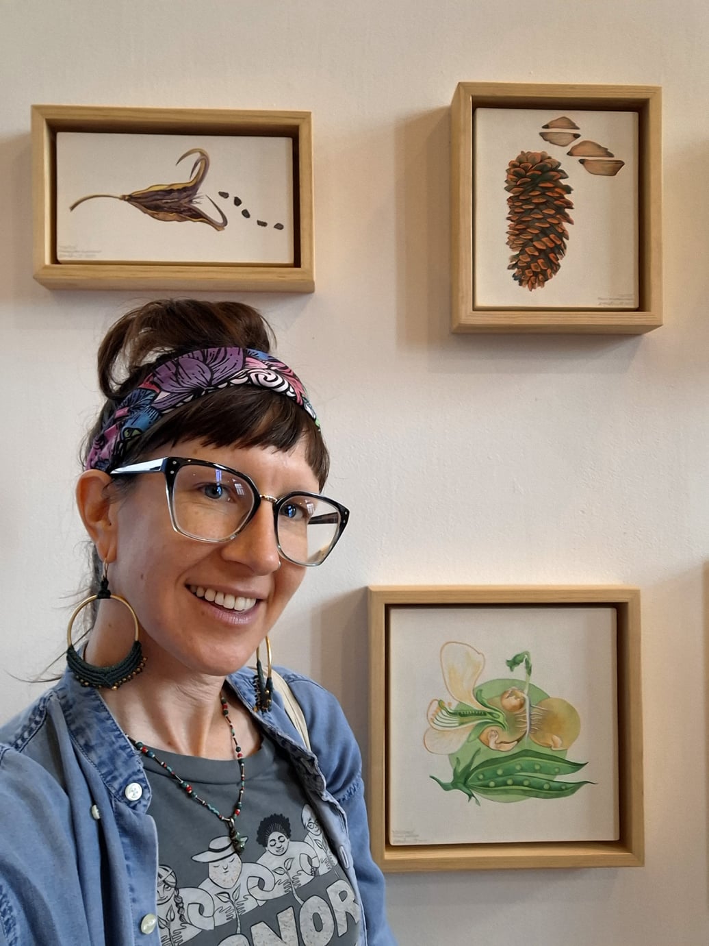 Artist Emily C-D with her paintings in the Semillas exhibit in Mexico City